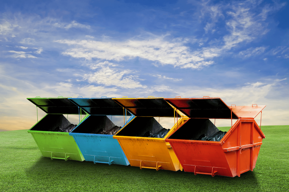 Dumpsters of various colors for rent on a field